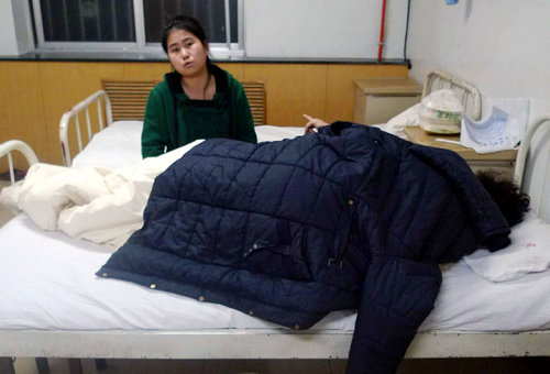 A woman takes care of a person injured by the explosion at a chemical plant in Lanzhou, capital of northwest China's Gansu province，January 7, 2010. 