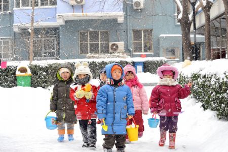 Children prepare to play with snow in a community of Shijingshan district, Beijing, China, Jan. 3, 2010. China&apos;s capital reported the heaviest daily snowfall in nearly six decades on Sunday, local meteorological bureau said January 4, 2009. [Xinhua]
