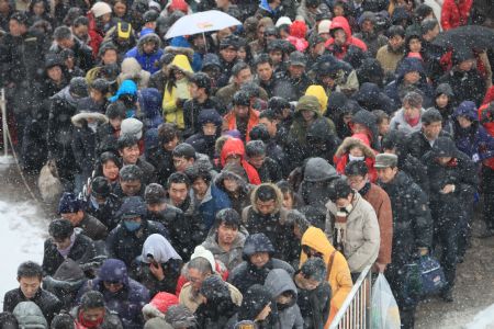 People queue for entering the subway station in front of the Beijing Railway Station in Beijing, China, Jan. 3, 2010.[Xinhua]