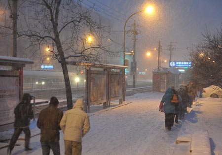People walk on a street during heavy snow in Beijing, China, Jan. 3, 2010. [Xinhua] 
