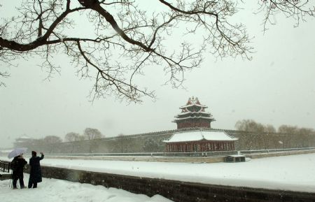 People take pictures of the snow-covered Forbidden City in Beijing, China, Jan. 3, 2010. Heavy snow hit Beijing on Sunday to close expressways, delay flights and disrupt bus services. [Xinhua] 