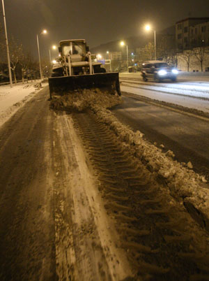 A bulldozer clears ice and snow in the early morning in downtown Yantai, east China&apos;s Shandong province, Jan. 4, 2010. The traffic in this costal city became seriously difficult as a snowstorm raided it on Monday. [Xinhua]