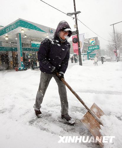 A gas station staff clears road in front of the station in Seoul, capital of South Korea, Jan. 4, 2010.[Xinhua]