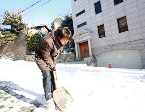 A man cleans road in Seoul, capital of South Korea, December 28. [Xinhua]