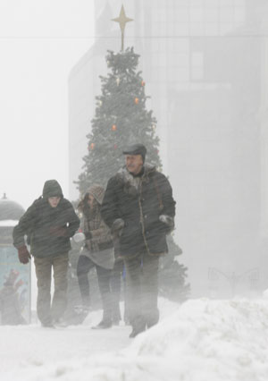 People walk under heavy snowfall in central Moscow, December 21, 2009.[Xinhua/Reuters]