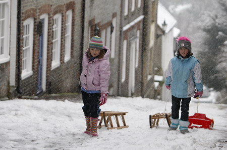 Two girls pull their sledges through the snow in Lewes, southeast England January 6, 2010.[Chinadaily.com.cn via agencies] 