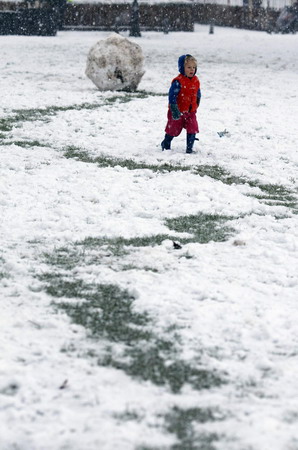 A child runs through the snow in Queen&apos;s Park in northwest London, January 6, 2010.[Chinadaily.com.cn via agencies] 