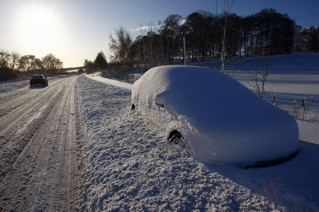 An abandoned car sits covered in snow on the A68 road near Earlston in the Scottish borders January 6, 2010.[Chinadaily.com.cn via agencies] 