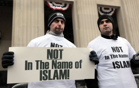 Arab-Americans Haider Koussan (L) and Ali Sayed hold signs as they join a demonstration in front of the Federal court building to demonstrate against terrorism, in Detroit, Michigan Jan. 8, 2010. (Xinhua/Reuters Photo) 