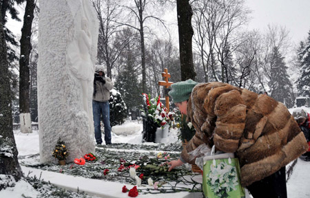 A woman offers flowers in front of Russian ballerina Galina Ulanova's tomb marking Ulanova's 100th birth anniversary, in Moscow, Russia, Jan. 8, 2010.(Xinhua/Gao Fan)