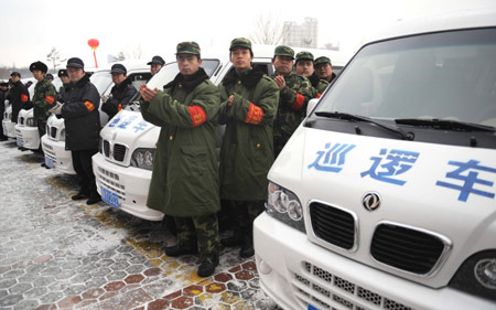 Representatives of communities stand beside vehicles that provide people with services in Urumqi, capital of northwest China's Xinjiang Autonomous Region, Jan. 9, 2010. Some companies and activists in Urumqi donated money to buy 555 vehicles. These vehicles were put into use Saturday in several communities to provide citizens with services.