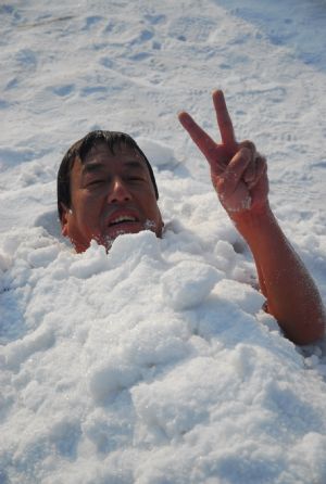 53-year-old Chen Kechai renders his cold-resistance stunt ability by being buried under the snow pile under the temperature of 10 more minus Celsius degrees, in Mudanjiang, northeast China's Heilongjiang Province, Jan. 10, 2010.(Xinhua/Chen Zhanhui)