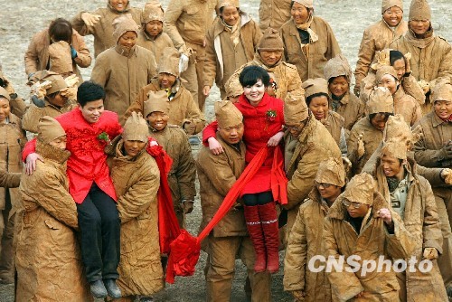 A special wedding featuring 'action art' is held on Sunday, January 10, 2010 on the bank of the Yellow River, in Zhengzhou, capital of central China's Henan Province. All guests attending the wedding ceremony dress like clay sculptures. [China News Service]