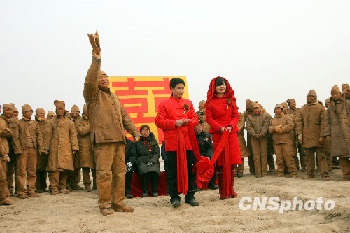 A special wedding featuring 'action art' is held on Sunday, January 10, 2010 on the bank of the Yellow River, in Zhengzhou, capital of central China's Henan Province. All guests attending the wedding ceremony dress like clay sculptures. [China News Service]