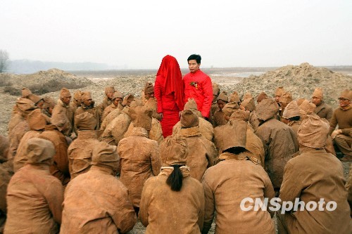 A special wedding featuring 'action art' is held on Sunday, January 10, 2010 on the bank of the Yellow River, in Zhengzhou, capital of central China's Henan Province. All guests attending the wedding ceremony dress like clay sculptures. [China News Service]