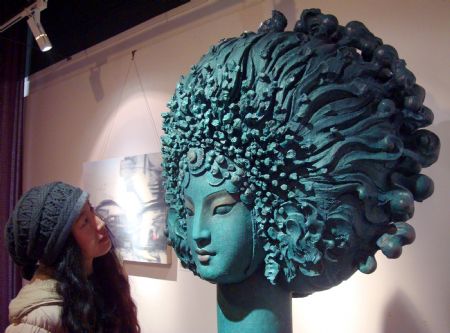 A girl admires a sculpture exhibited at the Suzhou oil painting and sculpture show in Suzhou, east China's Jiangsu Province, Jan. 9, 2010.