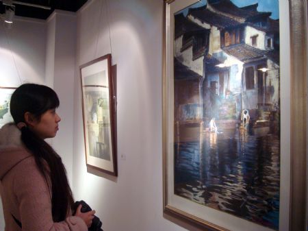 A girl admires a piece of oil painting works exhibited at the Suzhou oil painting and sculpture show in Suzhou, east China's Jiangsu Province, Jan. 9, 2010.