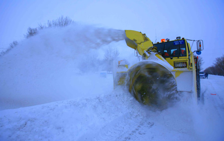 A machine cleans snow on the road of Habahe County in Aletai, northwest China&apos;s Xinjiang Uygur Autonomous Region, Jan. 6, 2010. A blizzard hit Aletai on Wednesday and would be expected to stop by Jan. 6 according to local weather apartment. The area has seen continuous blizzard and sharp temperature drop since December in 2009, which leads to serious disasters in agriculture and livestock breeding. [Xinhua]