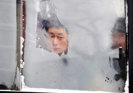 A person looks out from a frosting window of a bus in Harbin, northeast China&apos;s Heilongjiang Province, Jan. 7, 2010. [Xinhua]