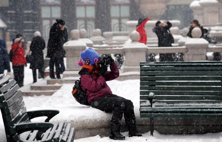 A tourist takes pictures of snow-covered landscape at a square in the downtown of Harbin, northeast China&apos;s Heilongjiang Province, Jan. 7, 2010.[Xinhua]