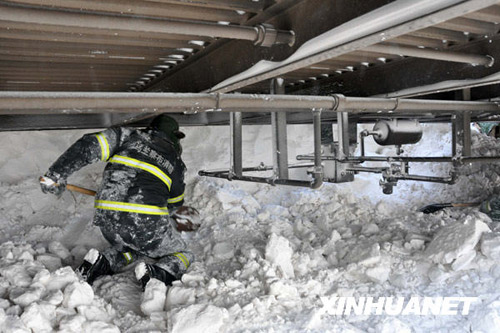 Armed policeman clears the snow covered railway in Shangdu, north China&apos;s Inner Mongolia Autonomous Region, January 4, 2010. Due to heavy snowfall on Sunday, several trains were delayed and some were stranded in remote areas in Inner Mongolia, January 4, 2010. More than 1,400 stranded passengers were settled in the safe neighborhood in Shangdu by 14:00 Monday. [Xinhua]