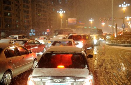 Photo Taken on Jan. 5, 2010 shows the traffic at a highway entrance in Jiujiang, southeast China&apos;s Jiangxi Province. The first snowfall hit Jiujiang on Tuesday. [Xinhua]