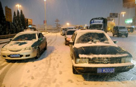 Photo Taken on Jan. 5, 2010 shows the traffic at a highway entrance in Jiujiang, southeast China&apos;s Jiangxi Province. The first snowfall hit Jiujiang on Tuesday. [Xinhua] 