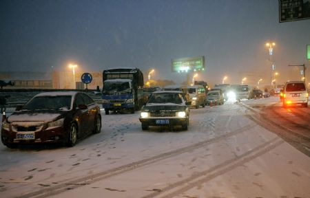 Photo Taken on Jan. 5, 2010 shows the traffic at a highway entrance in Jiujiang, southeast China&apos;s Jiangxi Province. The first snowfall hit Jiujiang on Tuesday. [Xinhua]