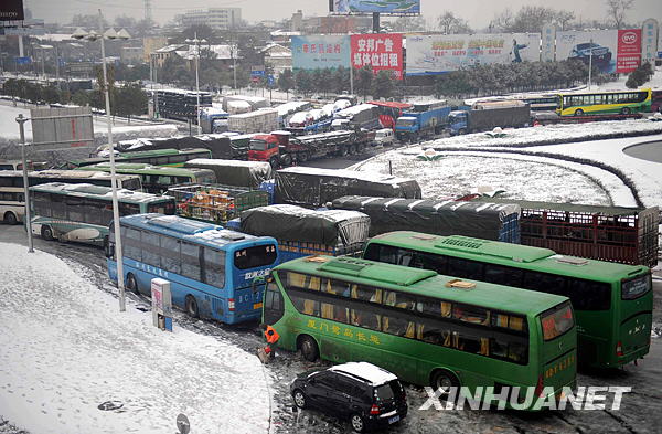 Photo Taken on Jan. 6, 2010 shows the traffic at a highway entrance in Jiujiang, southeast China&apos;s Jiangxi Province. The first snowfall hit Jiujiang on Tuesday. [Xinhua]