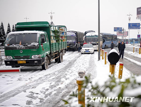 Photo Taken on Jan. 6, 2010 shows the traffic at a highway entrance in Jiujiang, southeast China&apos;s Jiangxi Province. The first snowfall hit Jiujiang on Tuesday. [Xinhua]