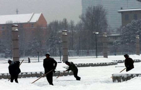 Staffs of Changchun cultural square clear snow on the square in Changchun, the capital of northeast China&apos;s Jilin Province, Dec. 28, 2009. Snow fell on northeast China&apos;s Jilin Province from west to east at Monday night. [Xinhua] 