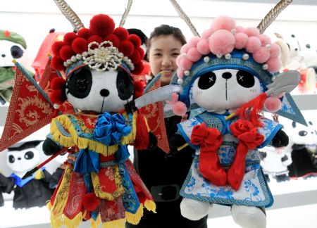 A saleswoman show off the cute Panda dolls in Peking Opera&apos;s makeup style, a novel doll brand series of Panda Town wrought by a group of young designers born after 1980s who returned to China after having finished education overseas, which is in limelight at a doll shop in Beijing, Jan. 10, 2010. [Luo Wei/Xinhua]