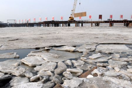 The under construction project of Jiaozhou Bay cross-ocean bridfge is stuck by ice in Qingdao, east China's Shandong Province, Jan. 10, 2010. The worst sea ice of the last three decades freezes in Qingdao's coastal waters, according to the data released by the North China Sea Branch (NCSB) of the State Oceanic Administration on Friday. (Xinhua/Li Ziheng)