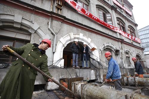 Workers prepare to move a century-old building to make way for an Expo project construction site. [Photo: Xinhua]