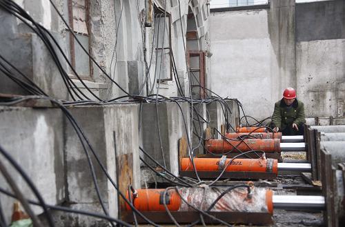 A worker monitors the jack operation. [Photo: Xinhua]