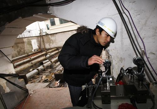 A technician monitors the moving process of the century-old building. [Photo: Xinhua]