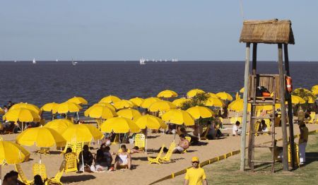 People enjoy the sunshine along the beach of La Plata river in Buenos Aires, the capital of Argentina, Jan. 9, 2010. [Marcelo Espinosa/Xinhua]