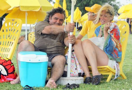 People enjoy the sunshine along the beach of La Plata river in Buenos Aires, the capital of Argentina, Jan. 9, 2010. [Marcelo Espinosa/Xinhua]v