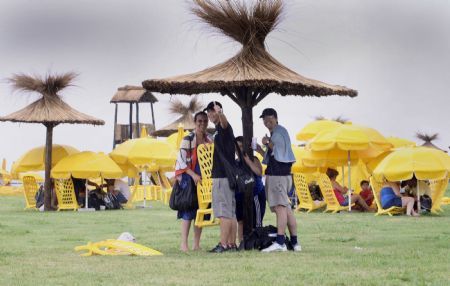 People enjoy the sunshine along the beach of La Plata river in Buenos Aires, the capital of Argentina, Jan. 9, 2010. [Marcelo Espinosa/Xinhua]