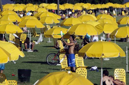 People enjoy the sunshine along the beach of La Plata river in Buenos Aires, the capital of Argentina, Jan. 9, 2010. [Marcelo Espinosa/Xinhua]