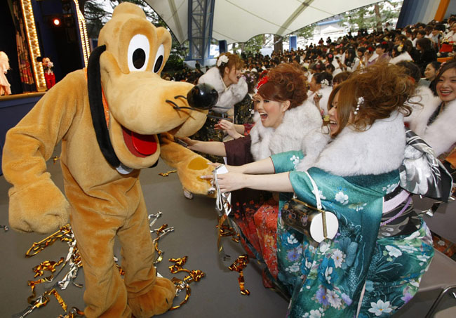 A group of Japanese girls, all dressed in festive long-sleeved kimonos for the occasion of a coming-of-age rite of passage ceremony, arrives at Tokyo Disneyland in Urayasu, east of Tokyo, on Monday, January 11, 2009. Some 11,000 boys and girls who reach age 20 this year were invited to the accession of adulthood celebration at the theme park. [Chinanews.com.cn]