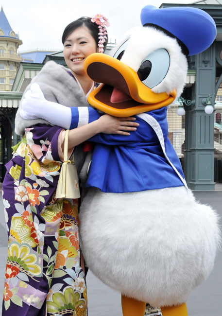 A Japanese girl, dressed in festive long-sleeved kimonos for the occasion of a coming-of-age rite of passage ceremony, poses for photo at Tokyo Disneyland in Urayasu, east of Tokyo, on Monday, January 11, 2009. Some 11,000 boys and girls who reach age 20 this year were invited to the accession of adulthood celebration at the theme park. [Chinanews.com.cn]