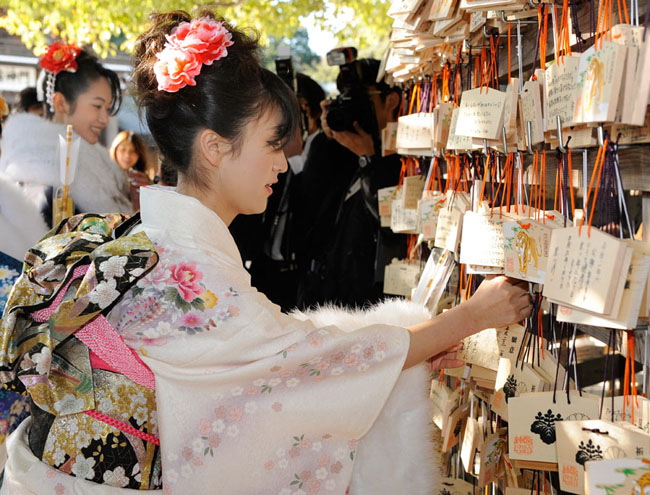 A group of Japanese girls, all dressed in festive long-sleeved kimonos for the occasion of a coming-of-age rite of passage ceremony, arrives at Tokyo Disneyland in Urayasu, east of Tokyo, on Monday, January 11, 2009. Some 11,000 boys and girls who reach age 20 this year were invited to the accession of adulthood celebration at the theme park. [Chinanews.com.cn]