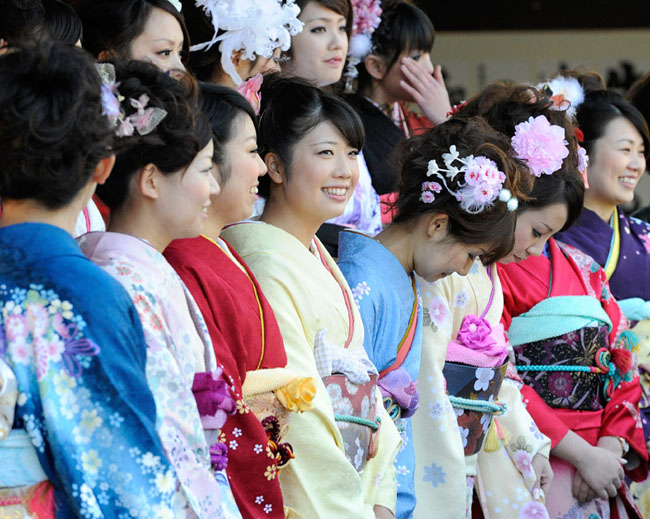 A group of Japanese girls, all dressed in festive long-sleeved kimonos for the occasion of a coming-of-age rite of passage ceremony, arrives at Tokyo Disneyland in Urayasu, east of Tokyo, on Monday, January 11, 2009. Some 11,000 boys and girls who reach age 20 this year were invited to the accession of adulthood celebration at the theme park. [Chinanews.com.cn]