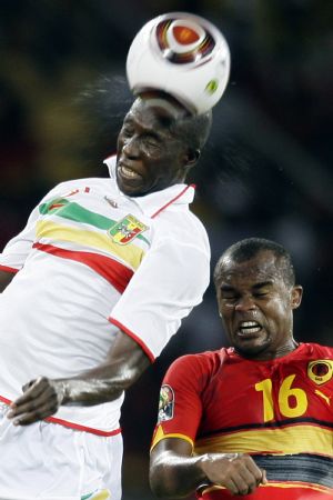 Amado Flavio of Angola (R) challenges Ousmane Berthe of Mali during the opening match of the African Nations Cup soccer tournament in Luanda January 10, 2010.(Xinhua/Reuters Photo)