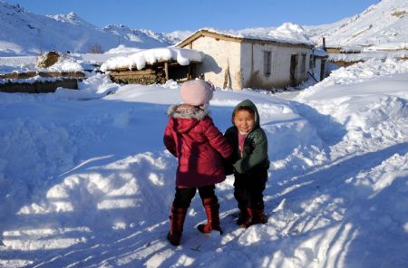 Kazak children play in the courtyard of their home in Keketuohai Town of northwest China's Xinjiang Uygur Autonomous Region, Jan. 10, 2010. [Xinhua]