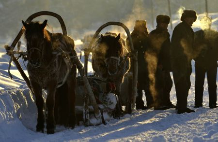 Kazak herdsmen transport their living goods on a sledge in Keketuohai Town of northwest China's Xinjiang Uygur Autonomous Region, Jan. 10, 2010. 