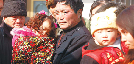 Wang Wanshan, 55, of Hekou, holds his granddaughter Wang Chengcheng, 4. She has an excessive blood-lead level - 279 mcg/l - but is yet to be treated.