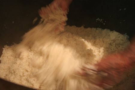 Ni Zhongyou mixes the wine powder and sticky rice to make yellow rice wine in Kebei Village in Qixian Township of Shaoxing County, east China's Zhejiang Province, Jan. 10, 2010. 