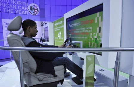 A boy experiences driving the Ford's Fusion hybrid car during the second press preview day of the 2010 North American International Auto Show (NAIAS) at Cobo center in Detroit, Michigan, U.S.A., Jan. 12, 2010. [Xinhua]